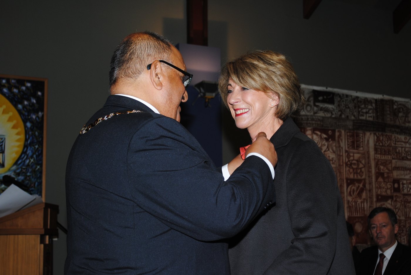 Christine Fernyhough smiling as the Governor-General pins on her New Zealand Order of Merit insignia